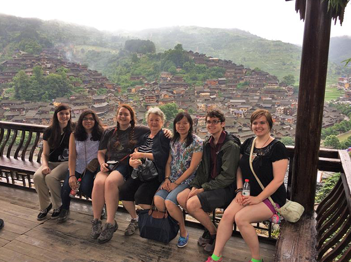 Students sitting on a bench in China with a USAC donor.